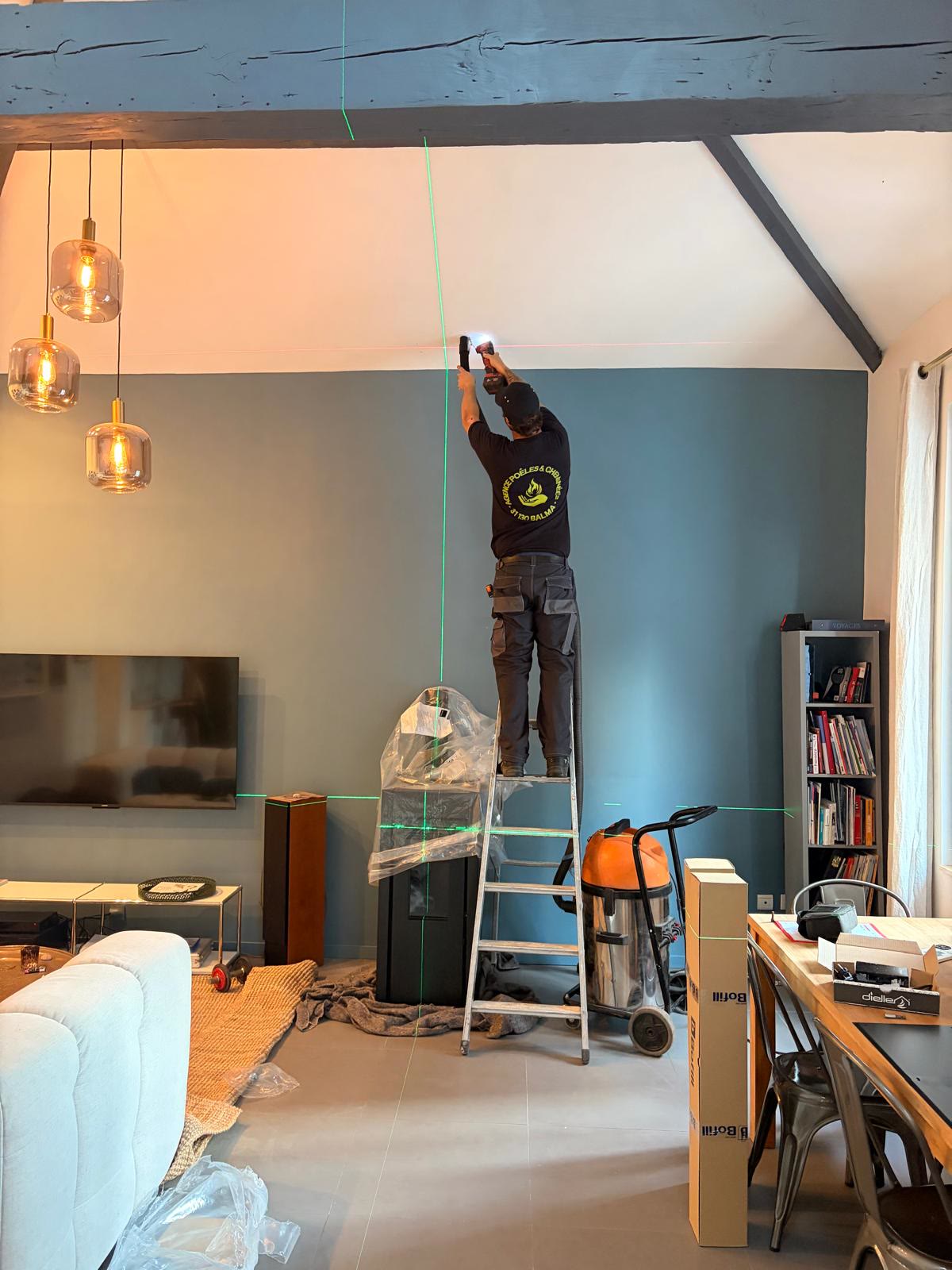 Technicien APC perçant le plafond guidé par un laser
