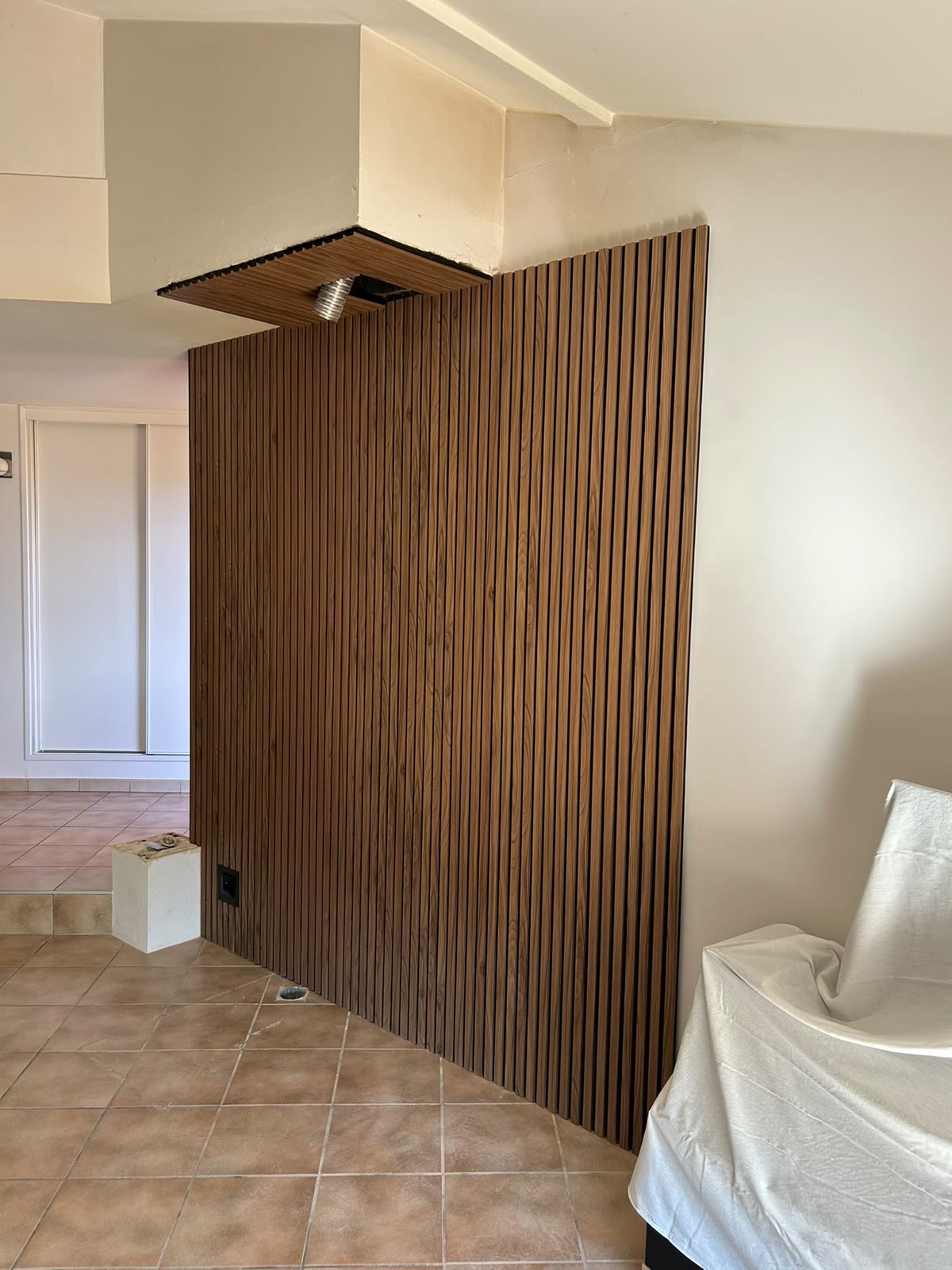 Mur entièrement habillé de lames bois avec caisson au plafond