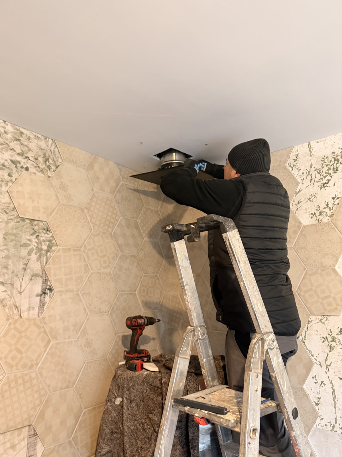 Technicien APC posant la plaque de finition du conduit au plafond
